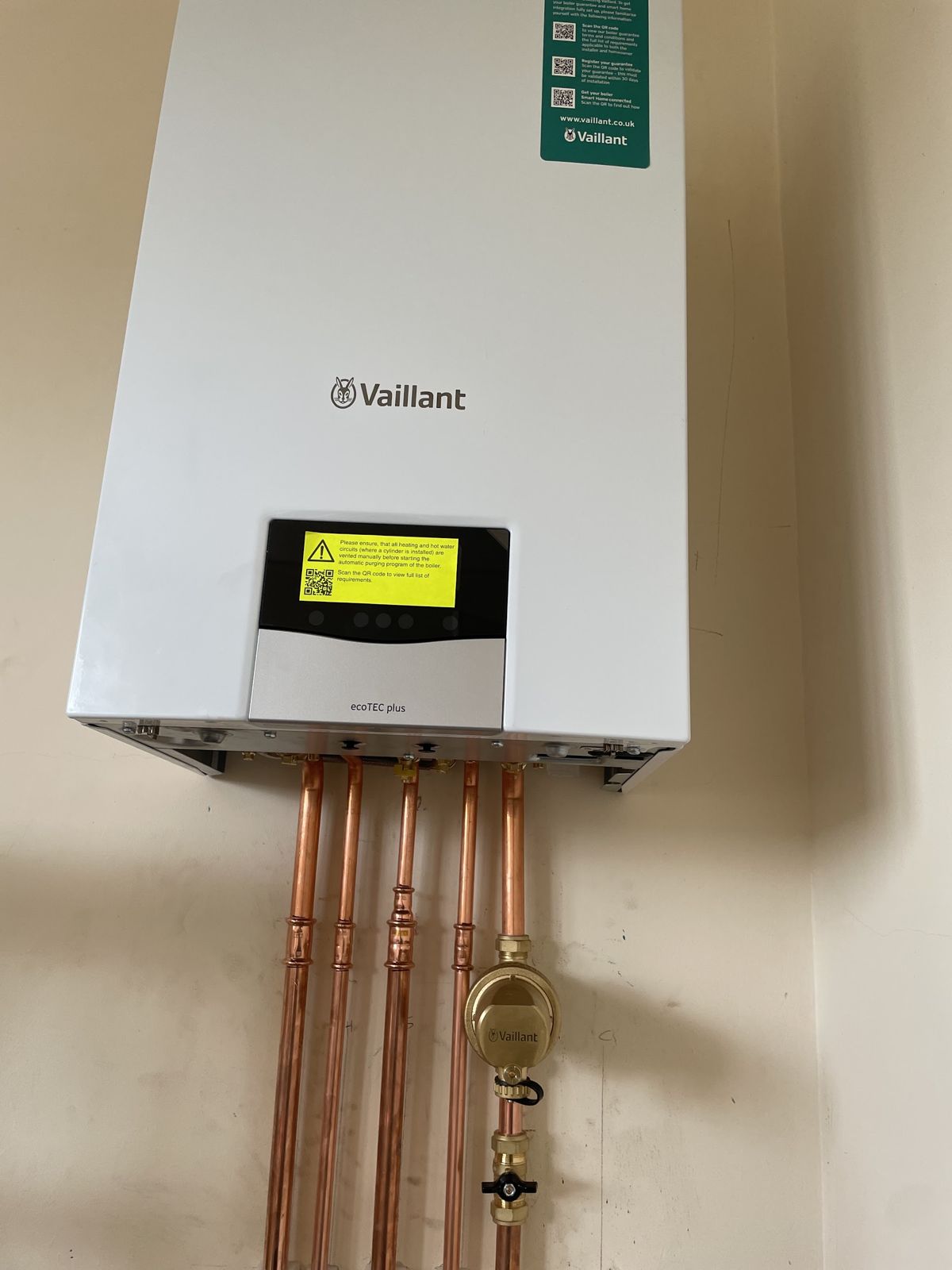 Vaillant combi boiler on the wall with copper pipework below