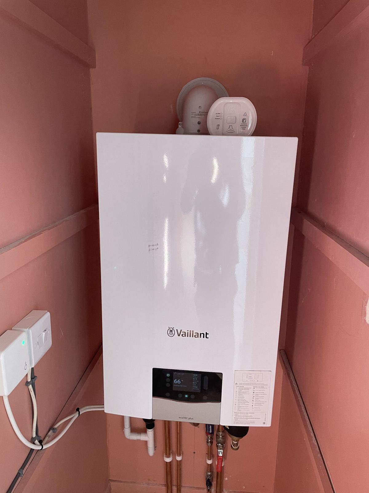 Vaillant boiler fitted in a pink-painted cupboard